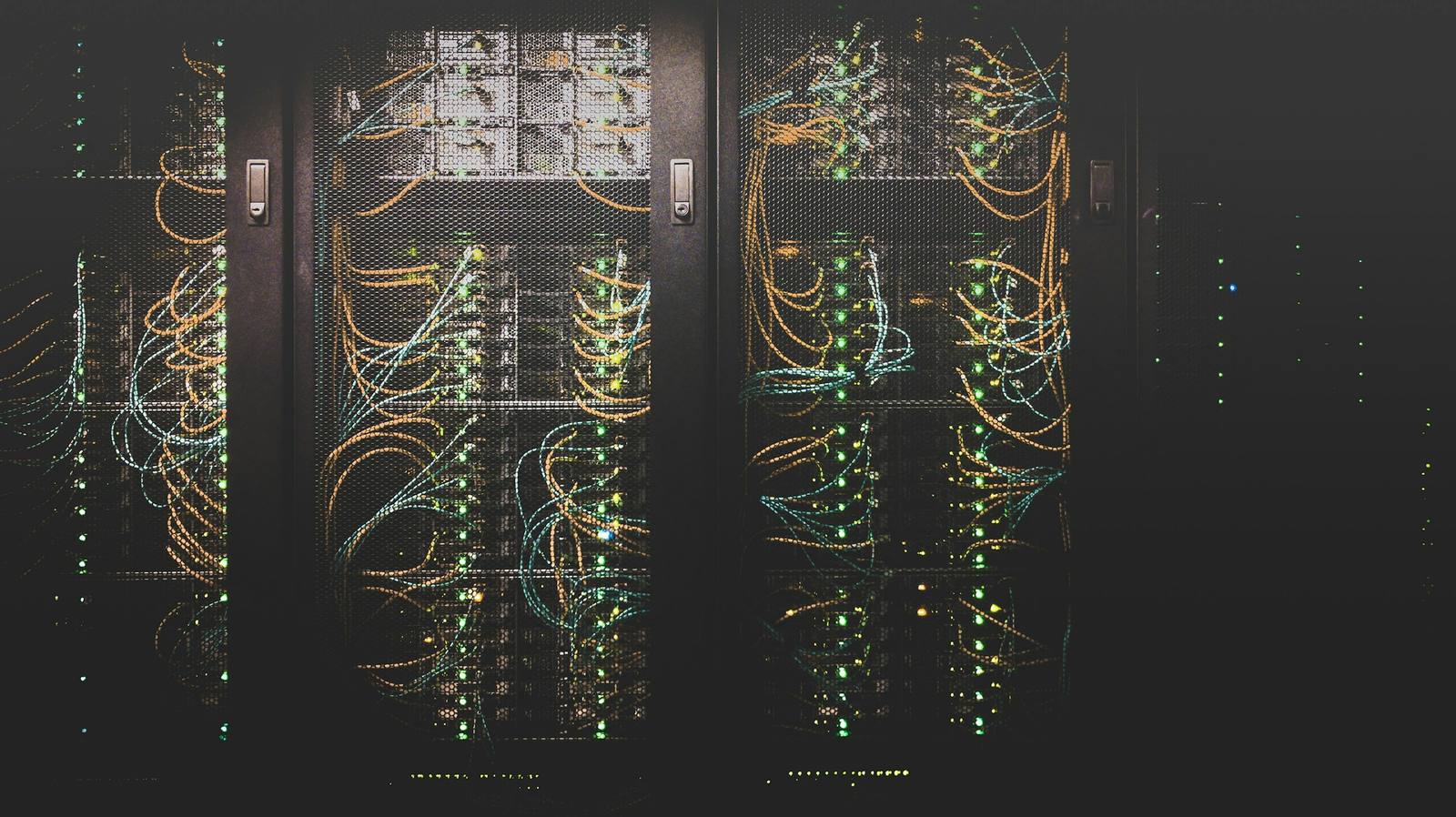 Corredor de racks iluminados em um data center, representando a infraestrutura em nuvem onde o Hal-AI UCS Cloud é hospedado.