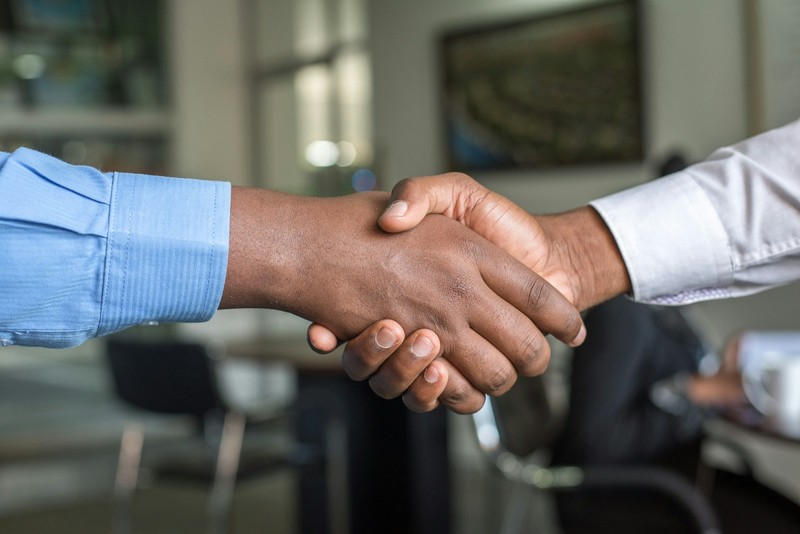 A job interview: two people talking across a table with a printed résumé on it